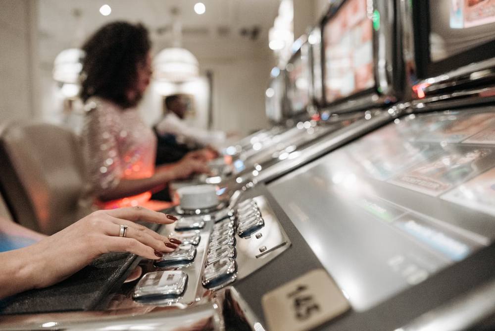 Barisan mesin slot digital dengan lampu warna-warni di lantai kasino